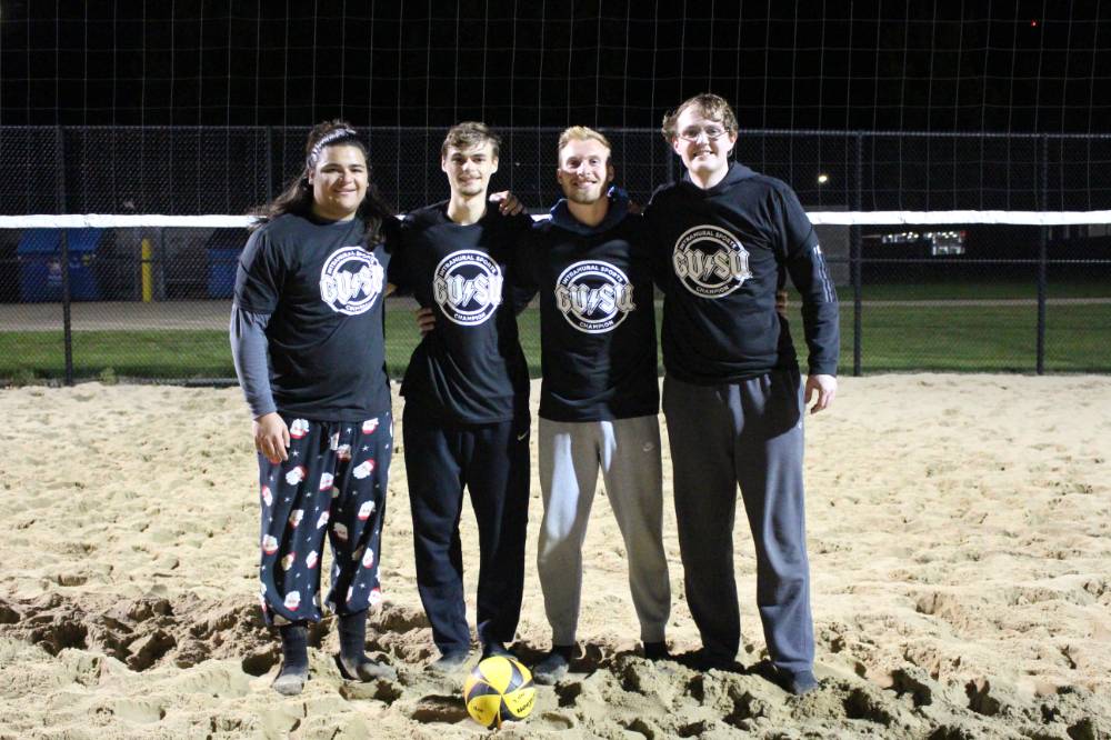 Students wearing championship shirts from a lower bracket sand volleyball tournament